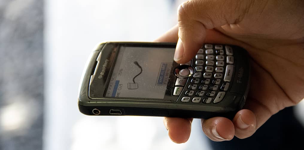 Hand holding a mobile phone as the user records and sends a voice memo